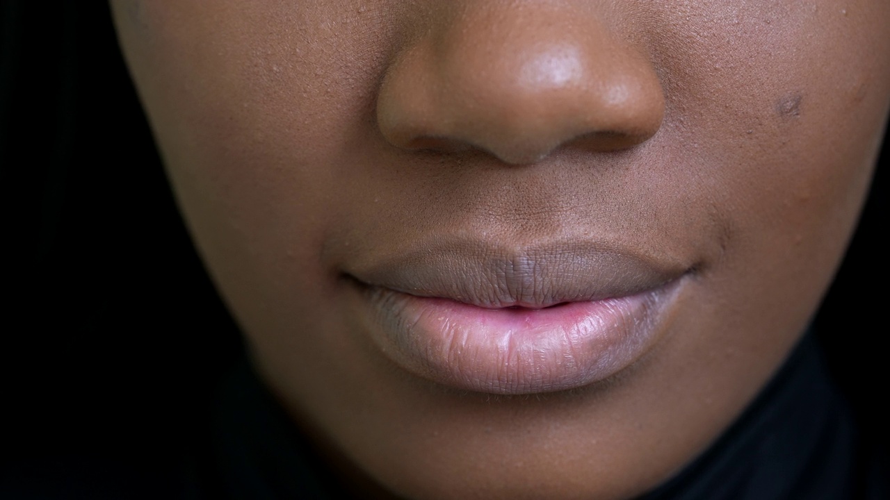 一个黑人女孩的近嘴，一个非洲妇女的脸宏观视频素材
