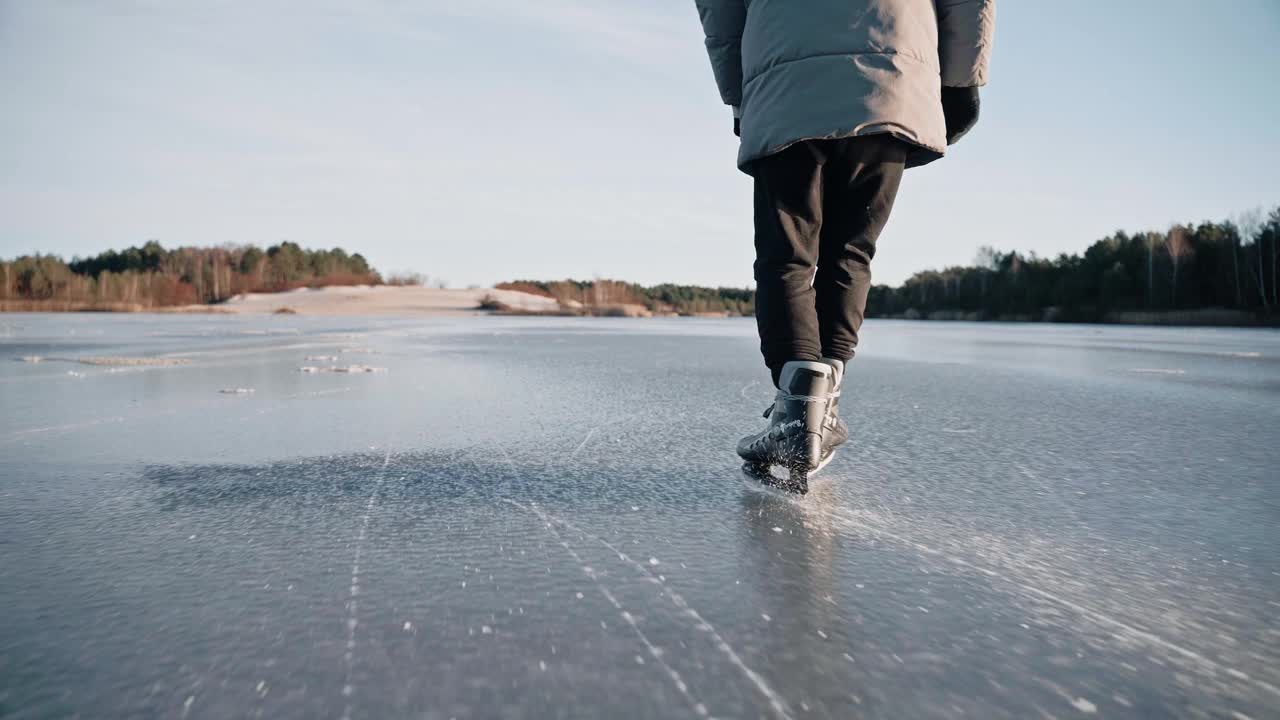 晴朗的一天，人们在清澈的冰湖上练习滑冰，使冰闪闪发光视频素材