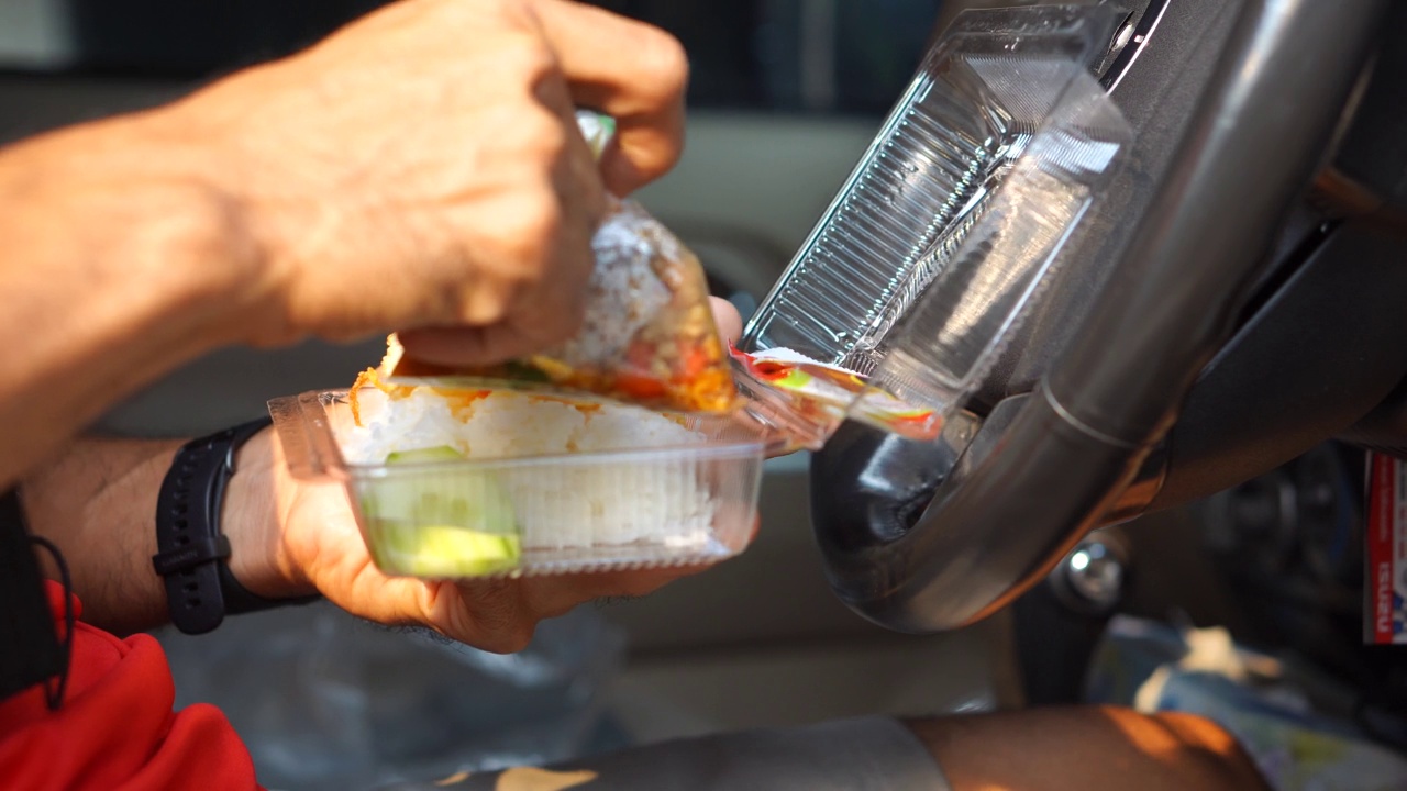 在车里吃盒饭的男人用煎蛋炒罗勒视频素材