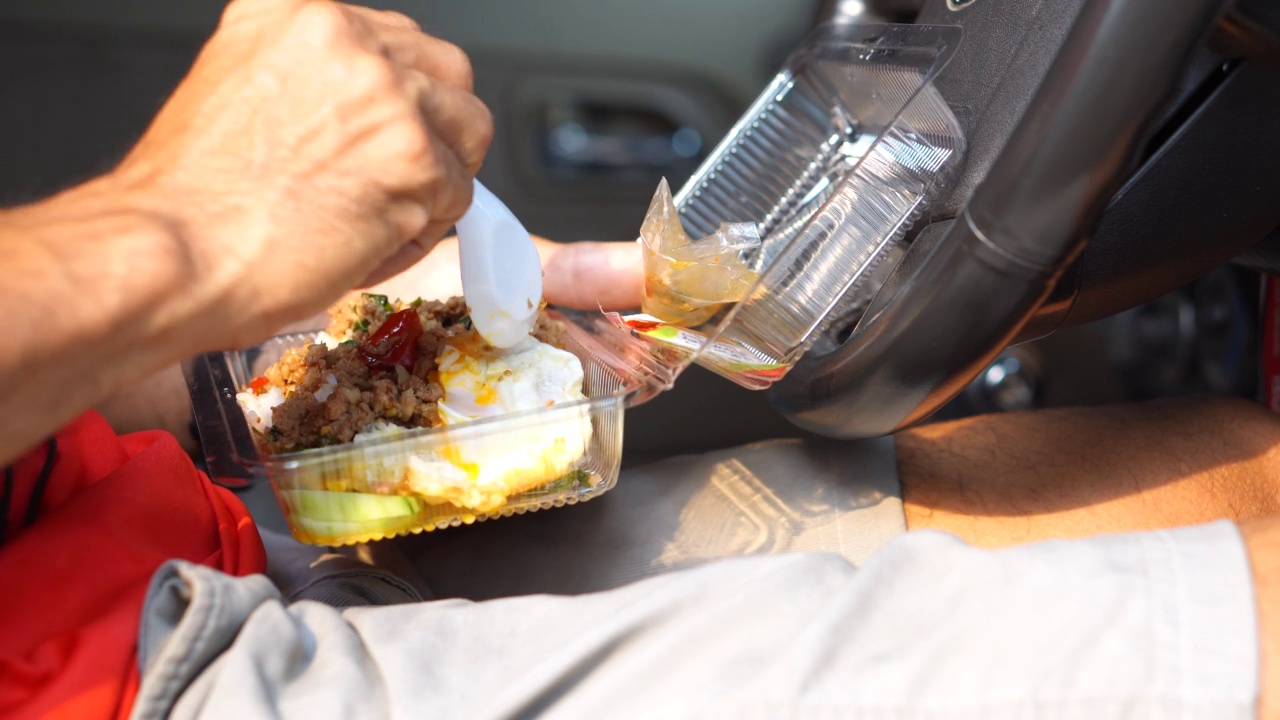 在车里吃盒饭的男人用煎蛋炒罗勒视频素材