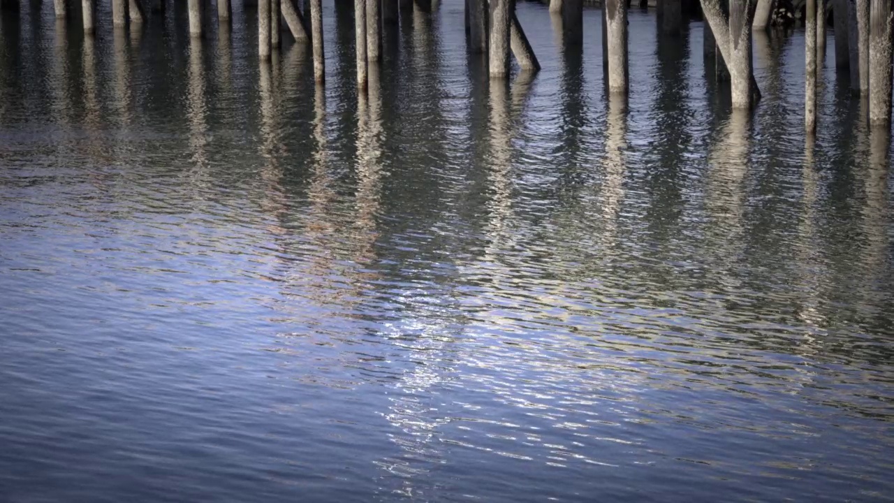 码头的水面图案反映着渔船视频素材