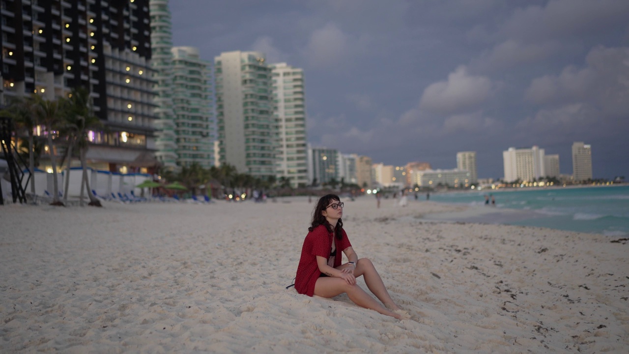 坐在坎昆酒店区的海滩上的女人视频下载