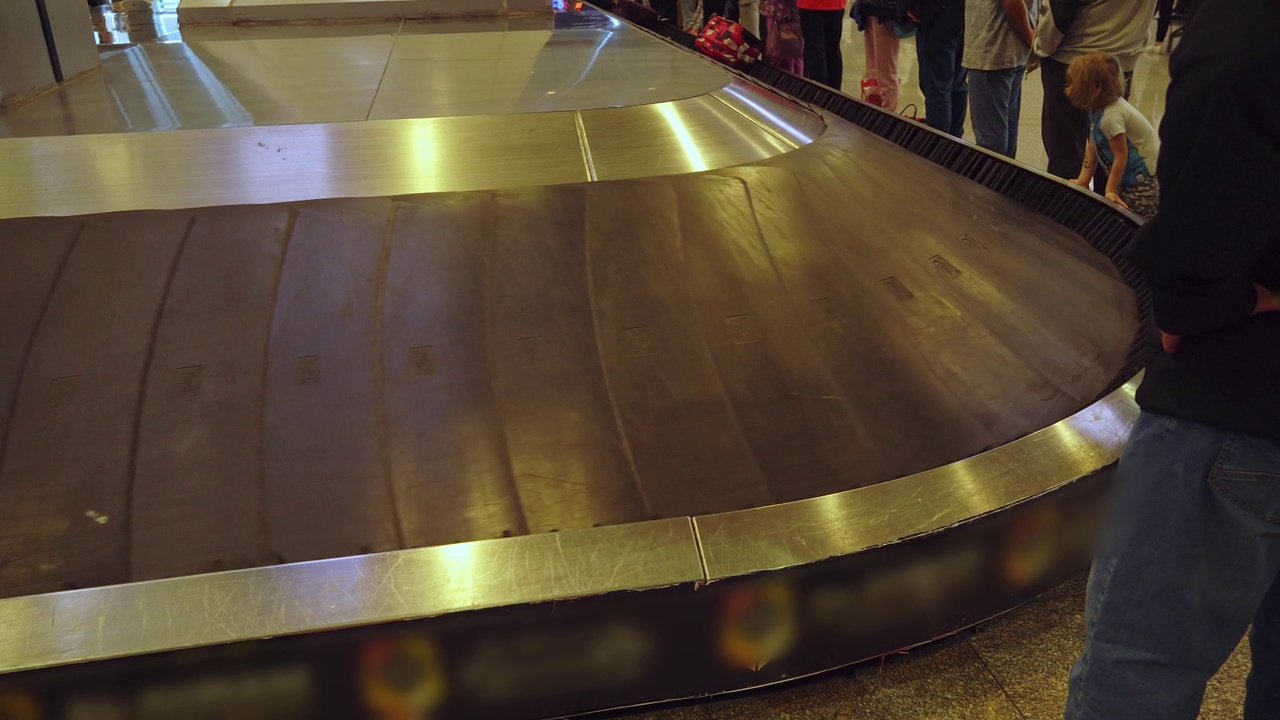 行李放在机场的行李传送带上。下飞机后，行李箱在胶带上旋转。视频下载