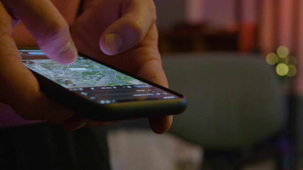 近距离拍摄的年轻白人男子的手使用移动智能手机使用地图应用程序获取方向前驾驶视频下载