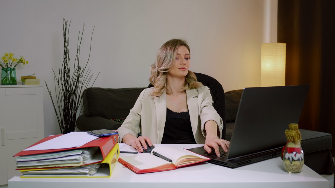 一个漂亮的非常专注的商业女性在笔记本电脑上工作的肖像。视频下载