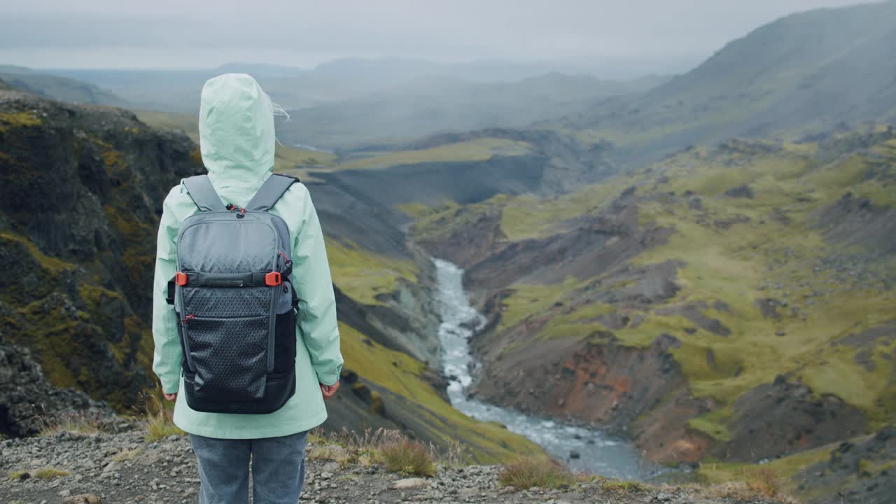 在冰岛高地上，一名女子背着背包欣赏海弗斯瀑布视频下载
