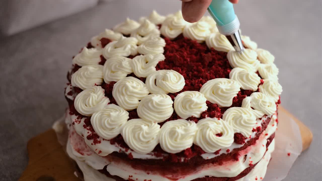 女人用奶油装饰红色天鹅绒蛋糕视频下载