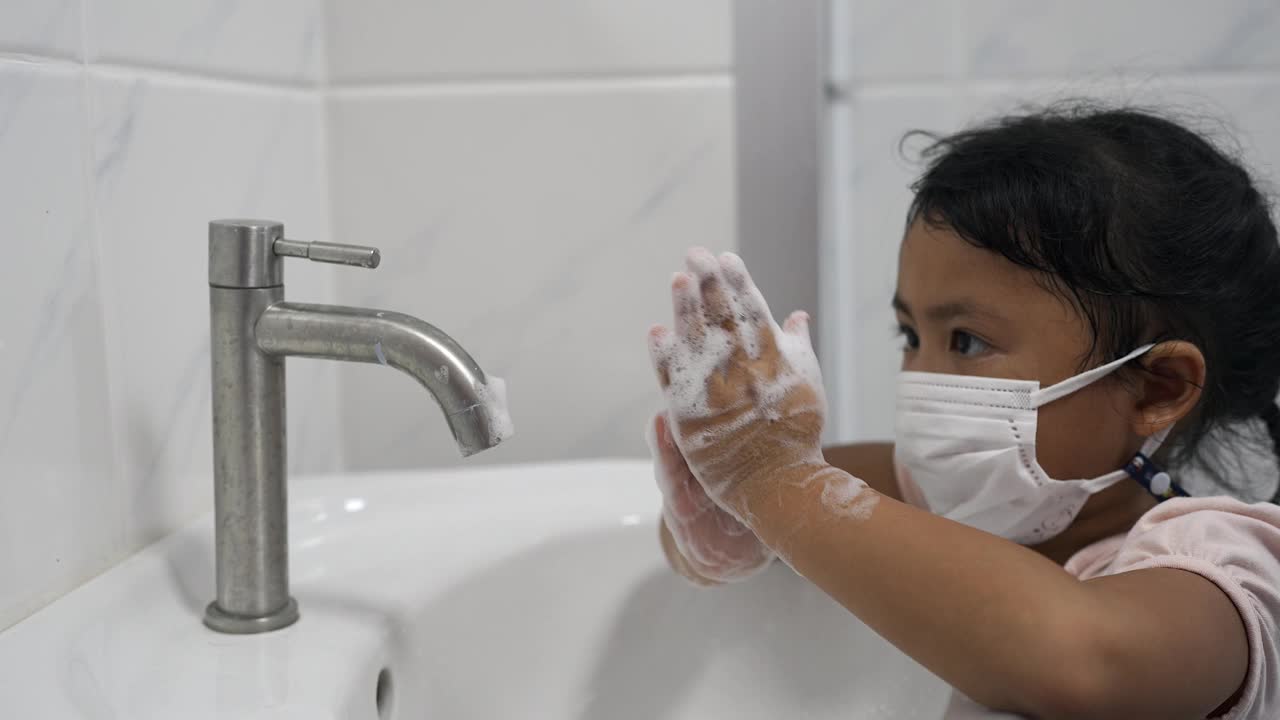 小孩在水池里用肥皂洗手。视频素材