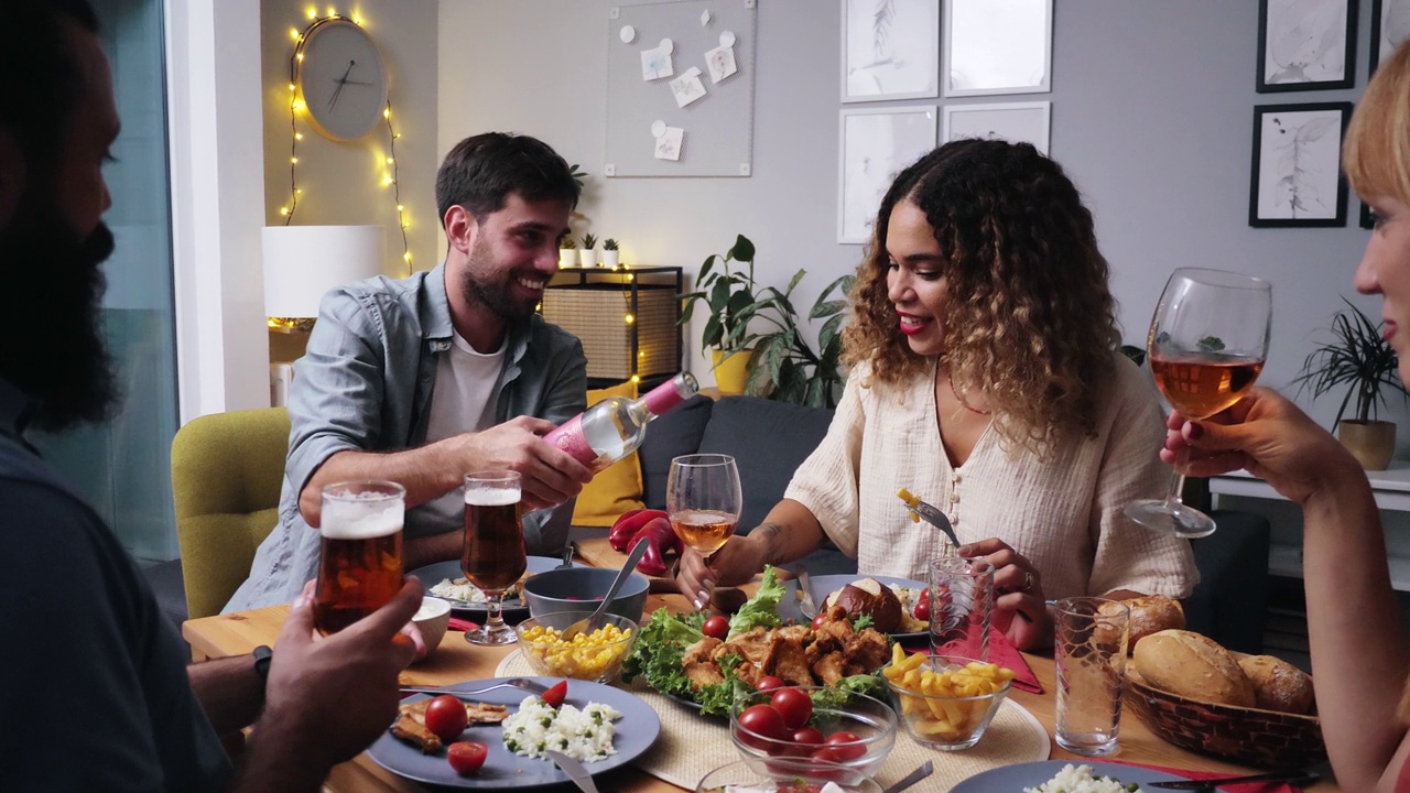 朋友和家人一起吃饭喝酒。举杯庆祝，喝葡萄酒和啤酒视频下载