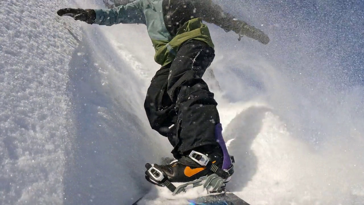 SLO MO自由式滑板滑雪运动员从积雪覆盖的斜坡上滑下视频素材
