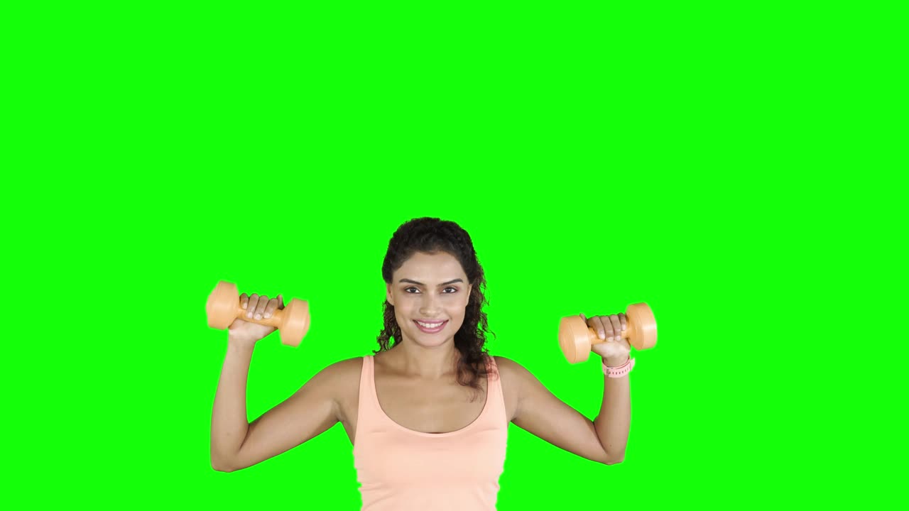年轻漂亮的女人用哑铃锻炼身体视频下载