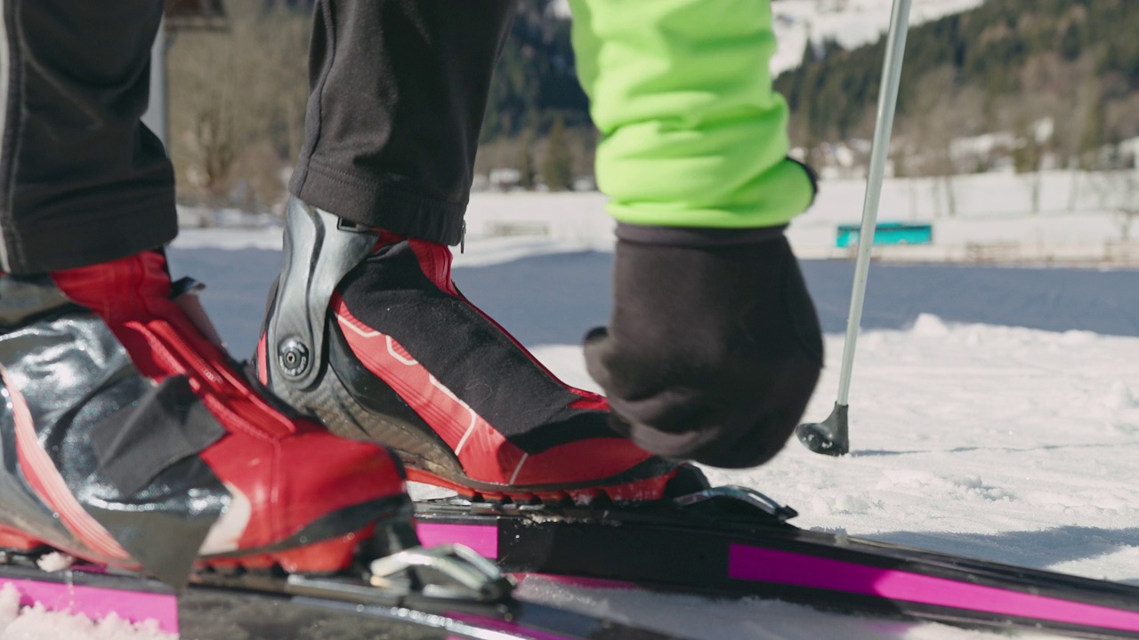 越野滑雪者双腿站立，穿上滑雪板，拉近距离视频下载