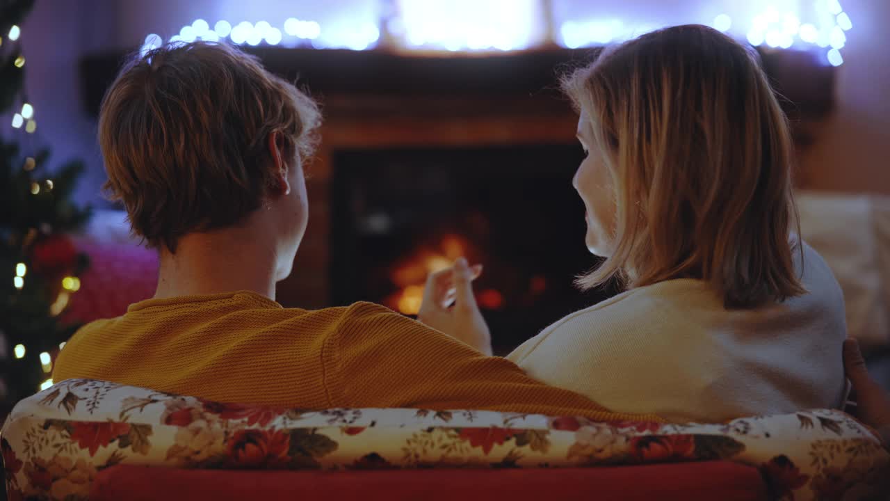 圣诞假期，一对年轻的情侣在温暖的客厅里视频素材