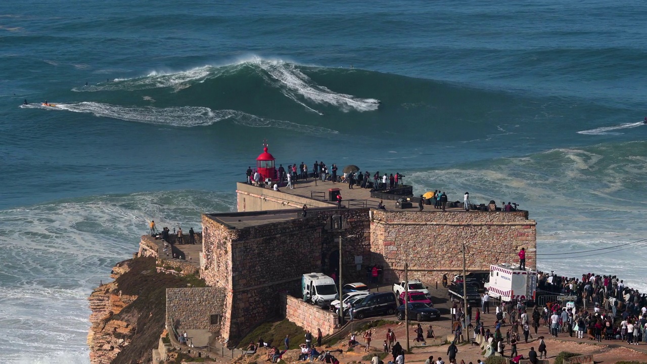 在葡萄牙纳扎尔的纳扎尔灯塔附近，巨浪冲浪者骑在巨浪上视频素材