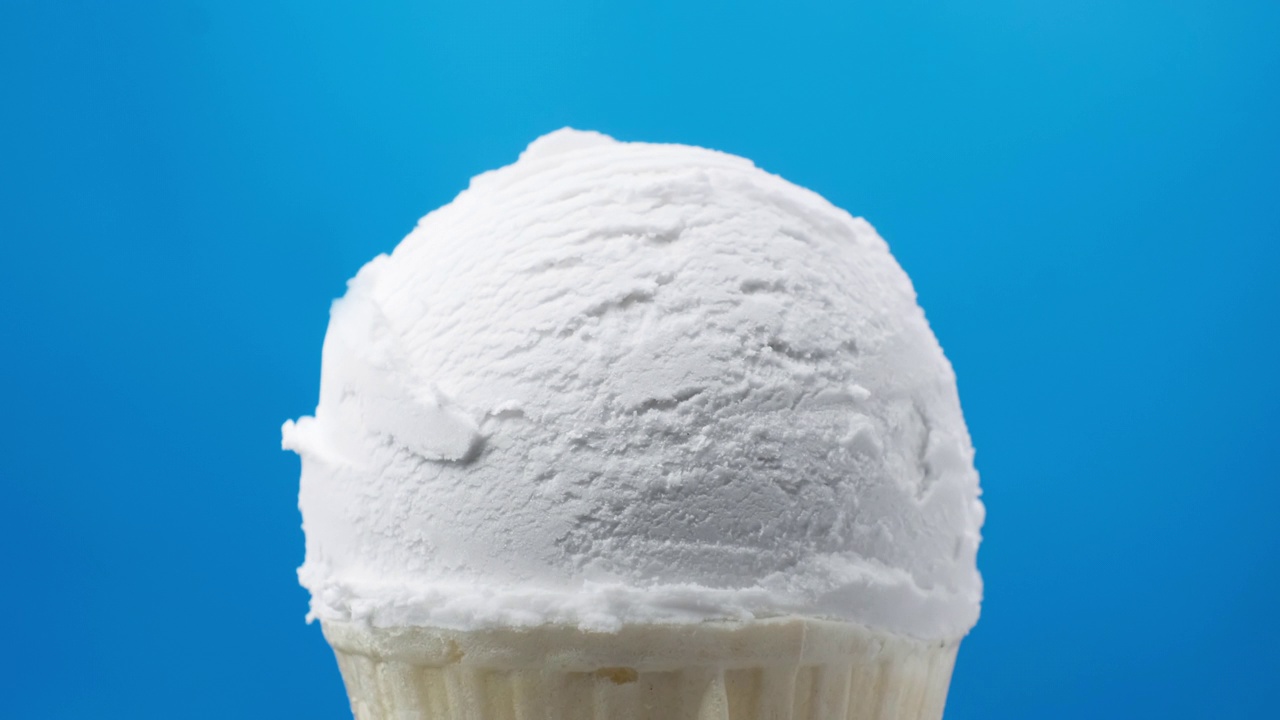 蓝色背景旋转香草冰淇淋。食品的概念。视频素材