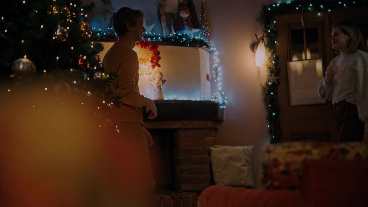 圣诞假期，一对年轻的恋人在壁炉前拥抱视频素材