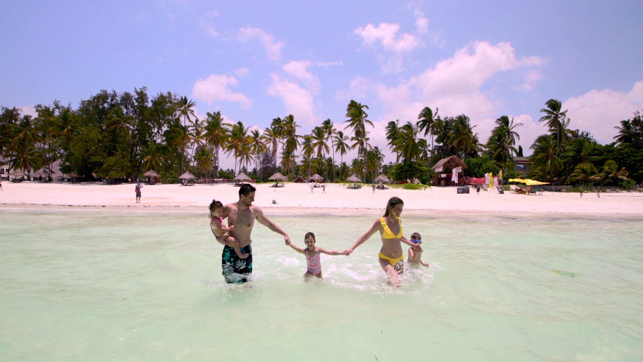 幸福的一家人，在夏日里，手牵着手，在大海中奔跑。视频下载