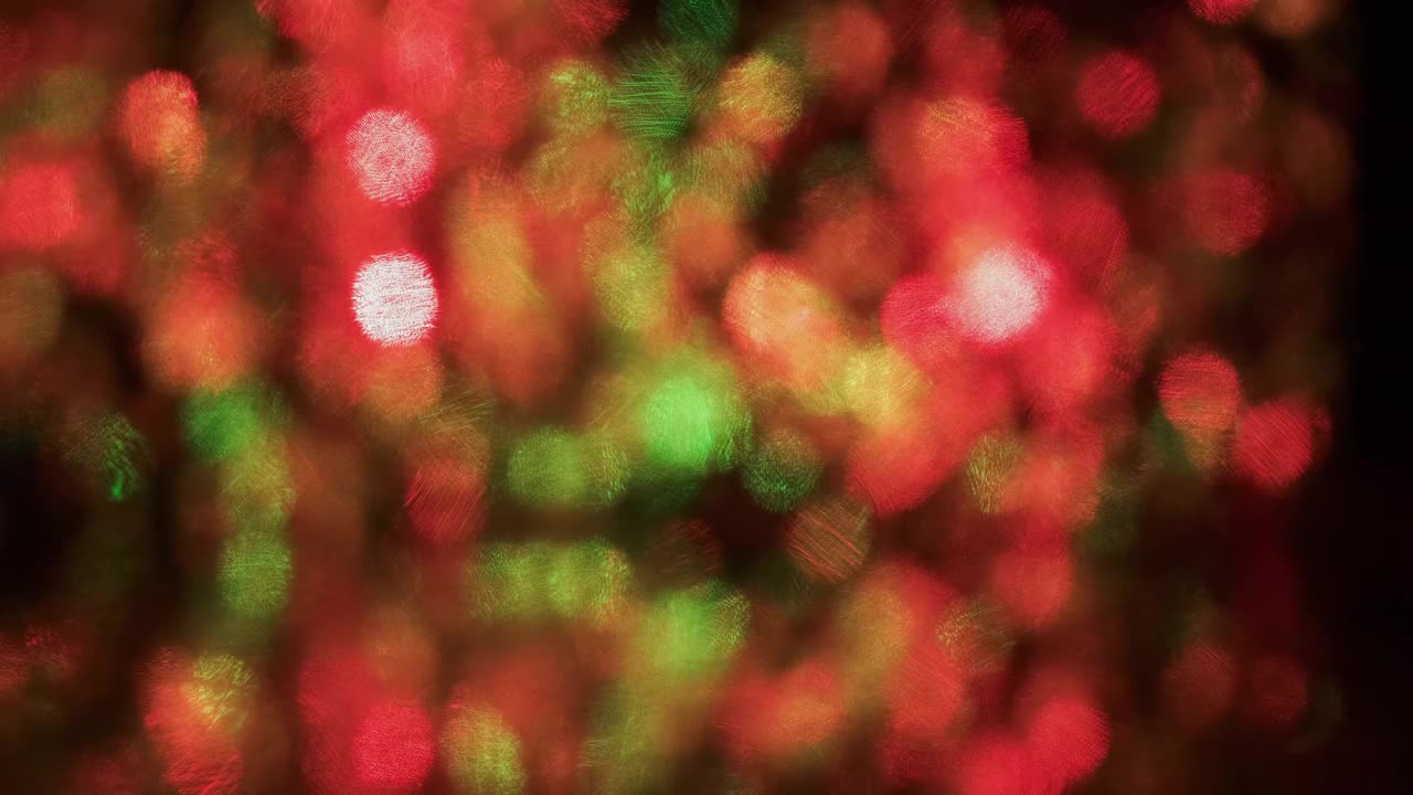 黑色背景上的彩色圣诞彩灯圆形散景。全景。闪烁和旋转的抽象背景视频下载