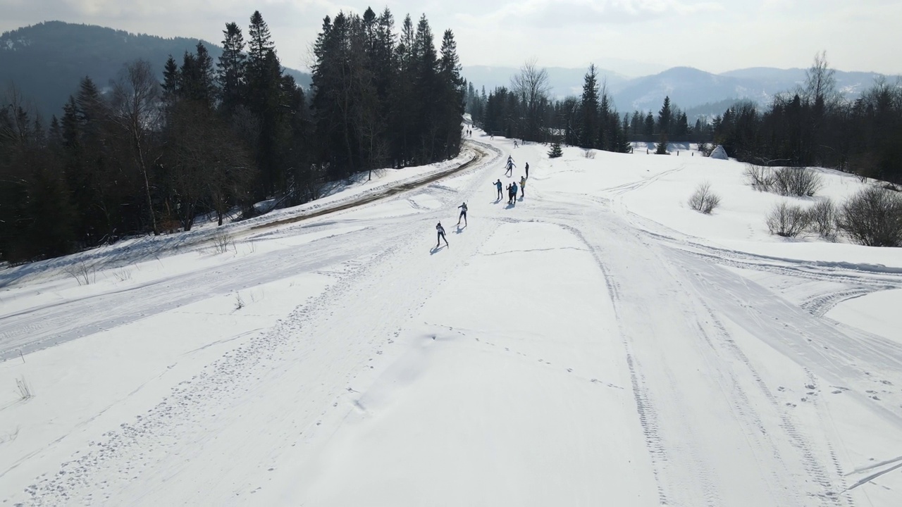 冬季高原上的冬季两项马拉松比赛中，滑雪者正在穿越赛道视频下载