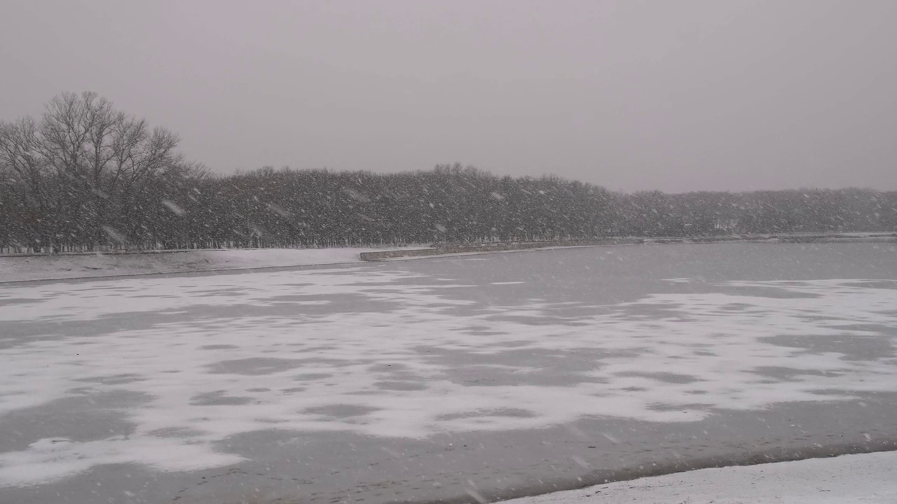 在降雪期间结冰的冬湖视频素材