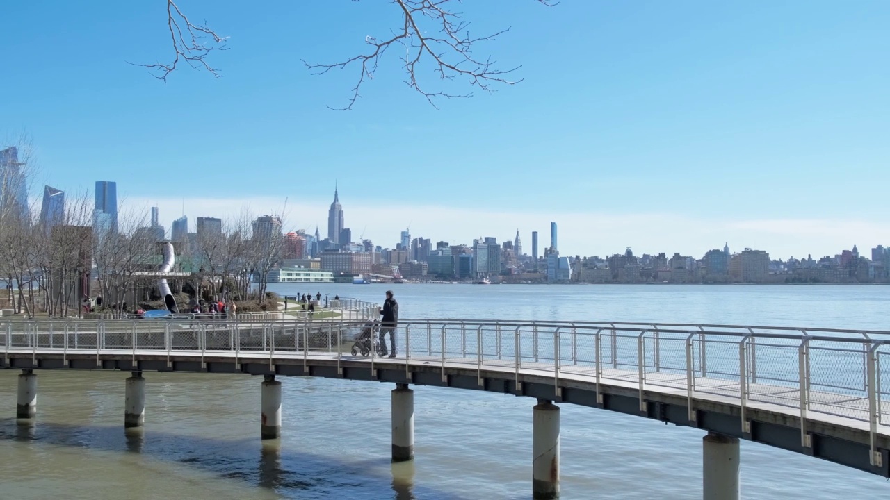 父亲和儿子走在桥公园与曼哈顿背景4K视频下载