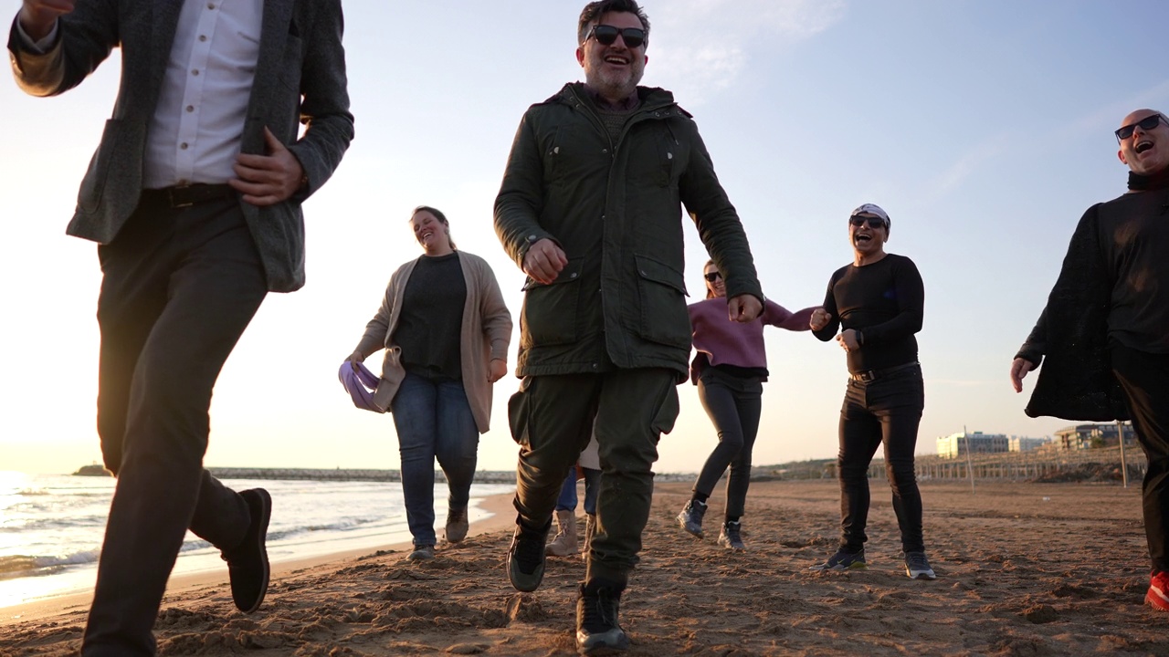 慢动作:多种族人群在日落的海滩上奔跑视频素材