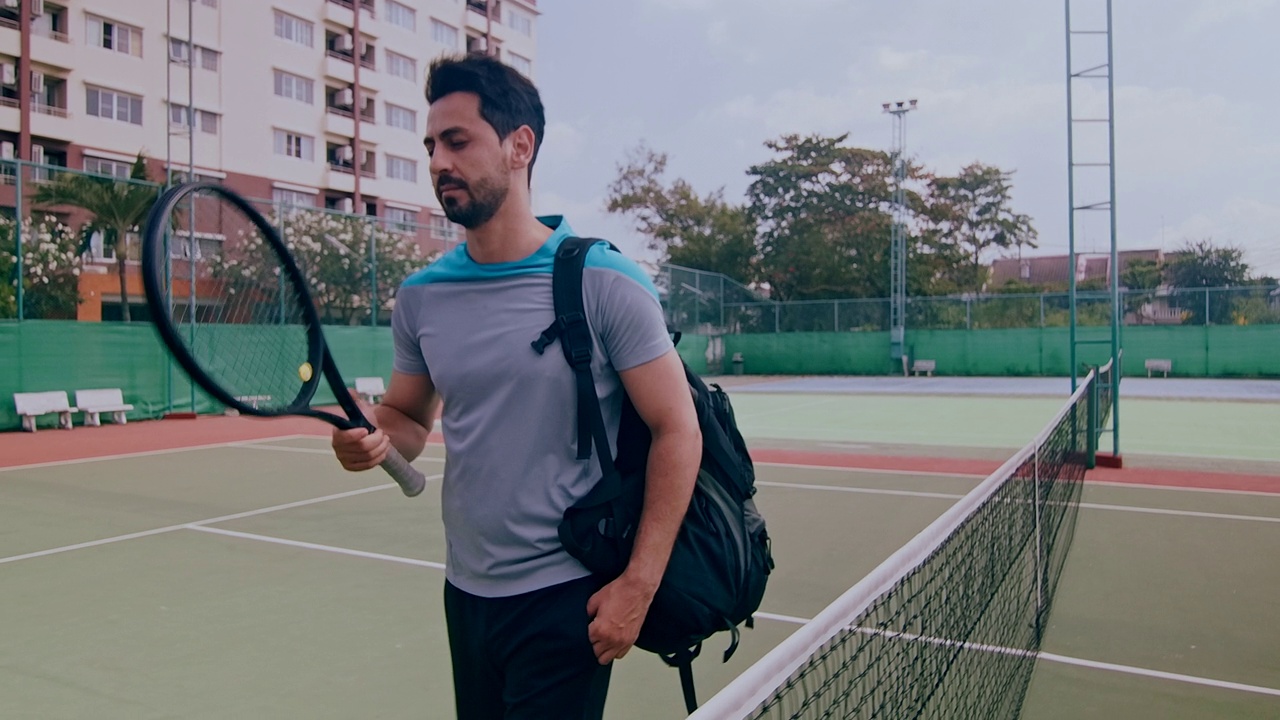 中东男子走进网球场的慢镜头。视频下载