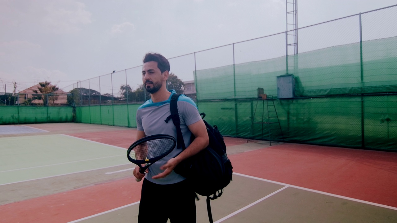 中东男子走进网球场的慢镜头。视频下载