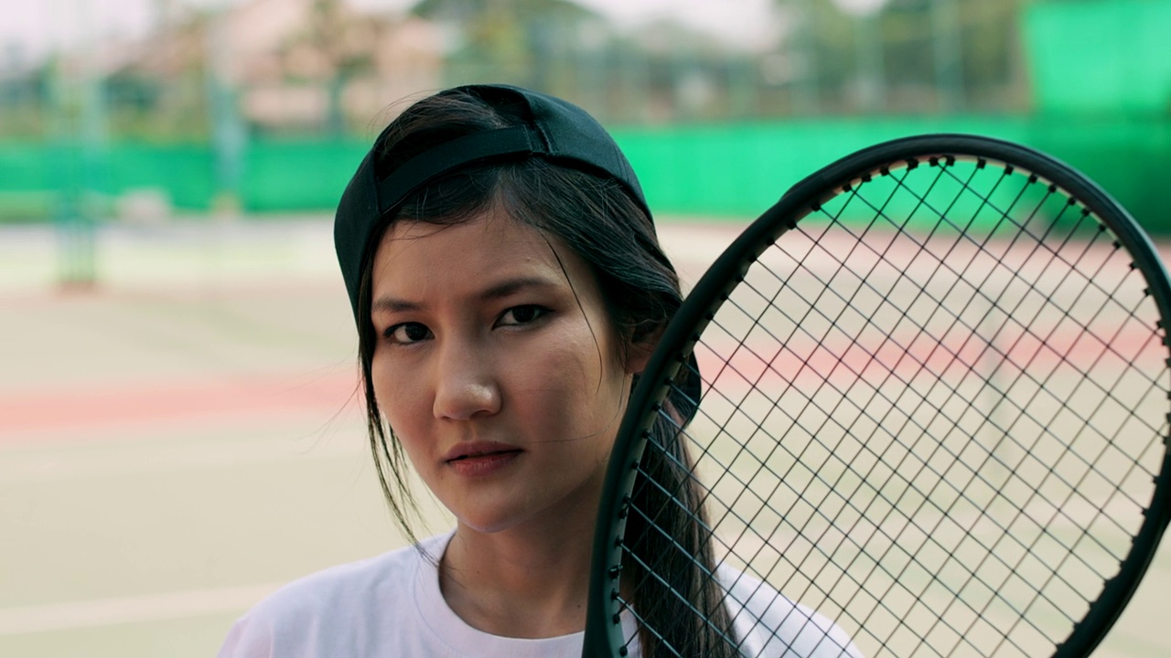年轻女子网球场的肖像。严肃的表情。视频下载