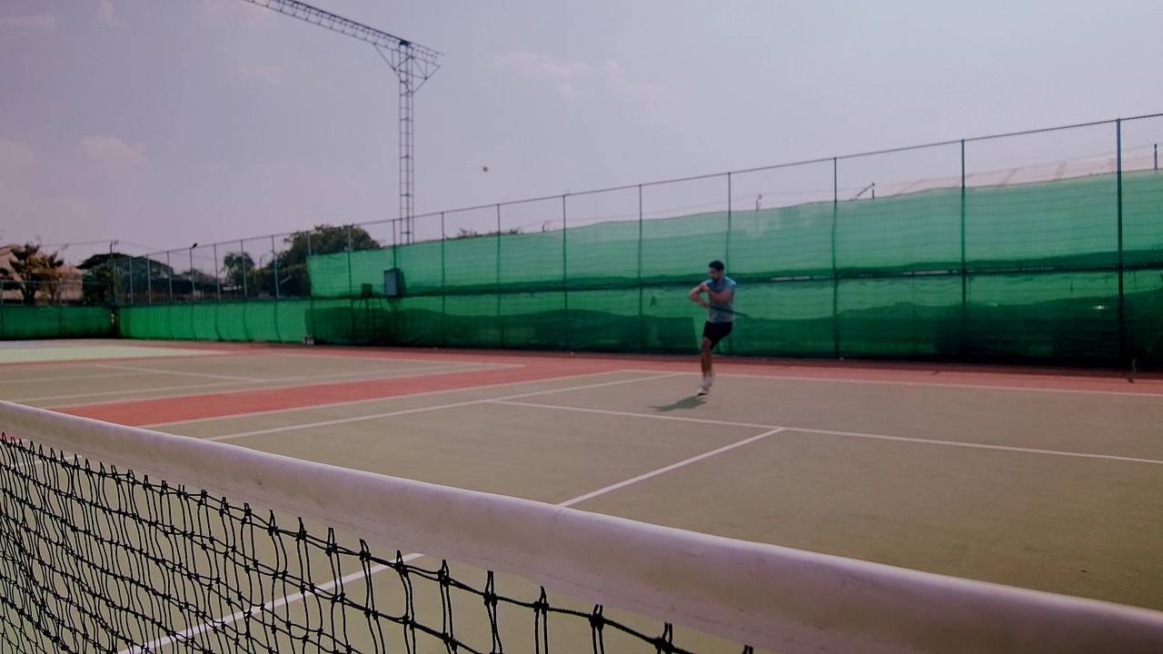 中东男子跑去打网球的慢镜头。视频下载
