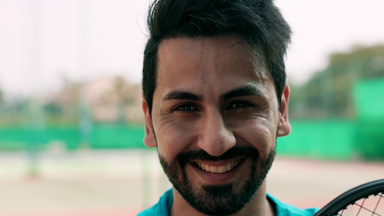 中东男子在网球场的肖像。面带微笑。视频下载