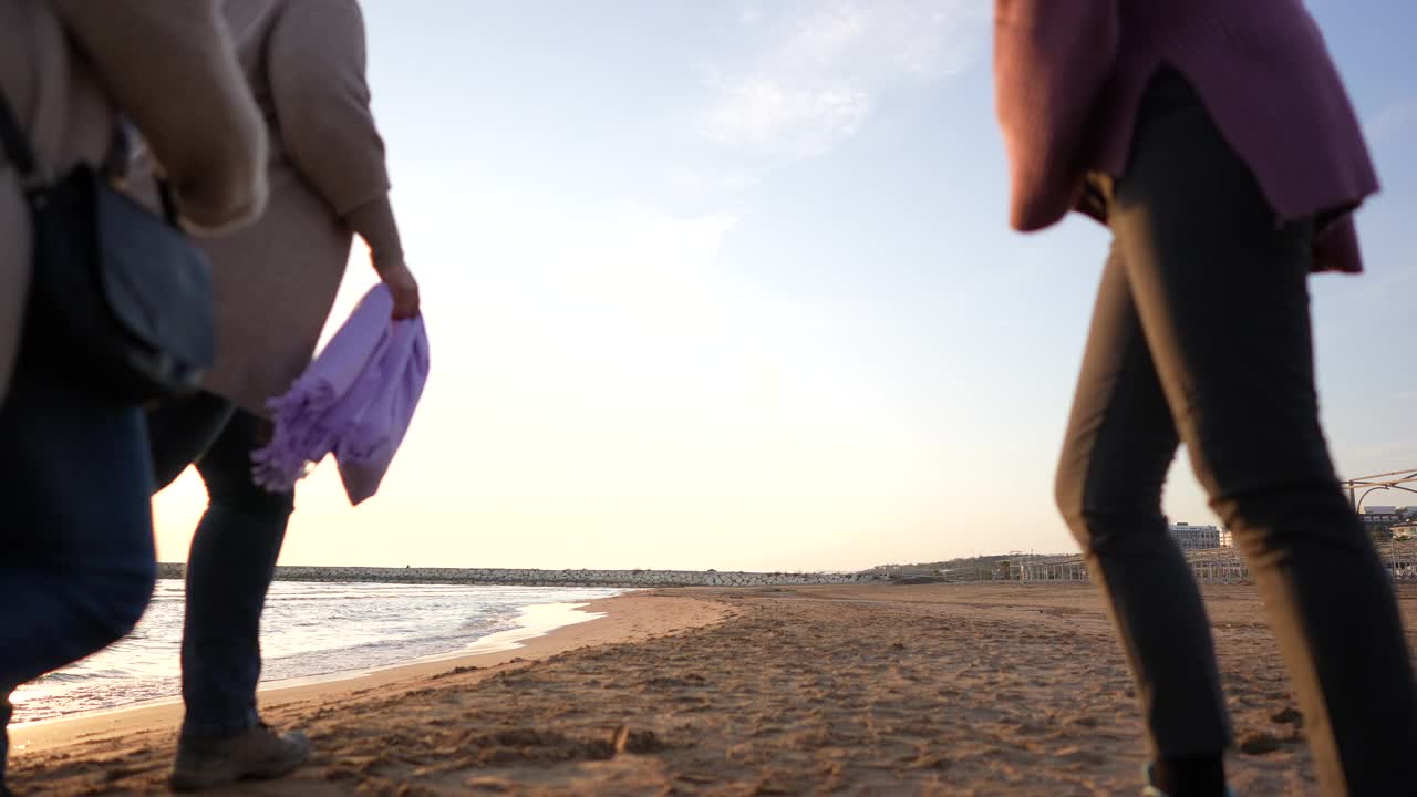 慢镜头后视镜:多种族人群在日落时分的海滩上奔跑视频素材