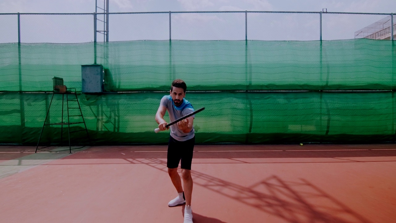 一名中东男子准备在网球场上发球的慢镜头。放大照片。视频下载