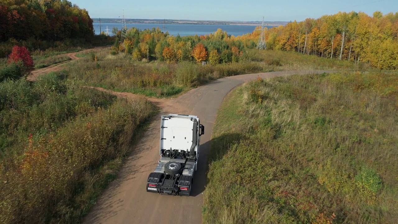 没有拖车的卡车在公路上行驶的鸟瞰图。独自行走在密密平坦的森林沥青路上，在河边笔直的空旷道路上视频下载