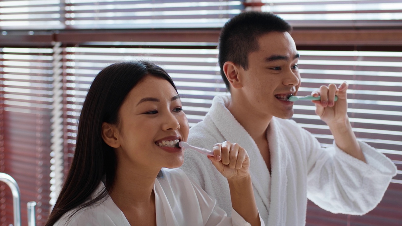 快乐的日本夫妇在现代浴室用牙刷刷牙视频下载