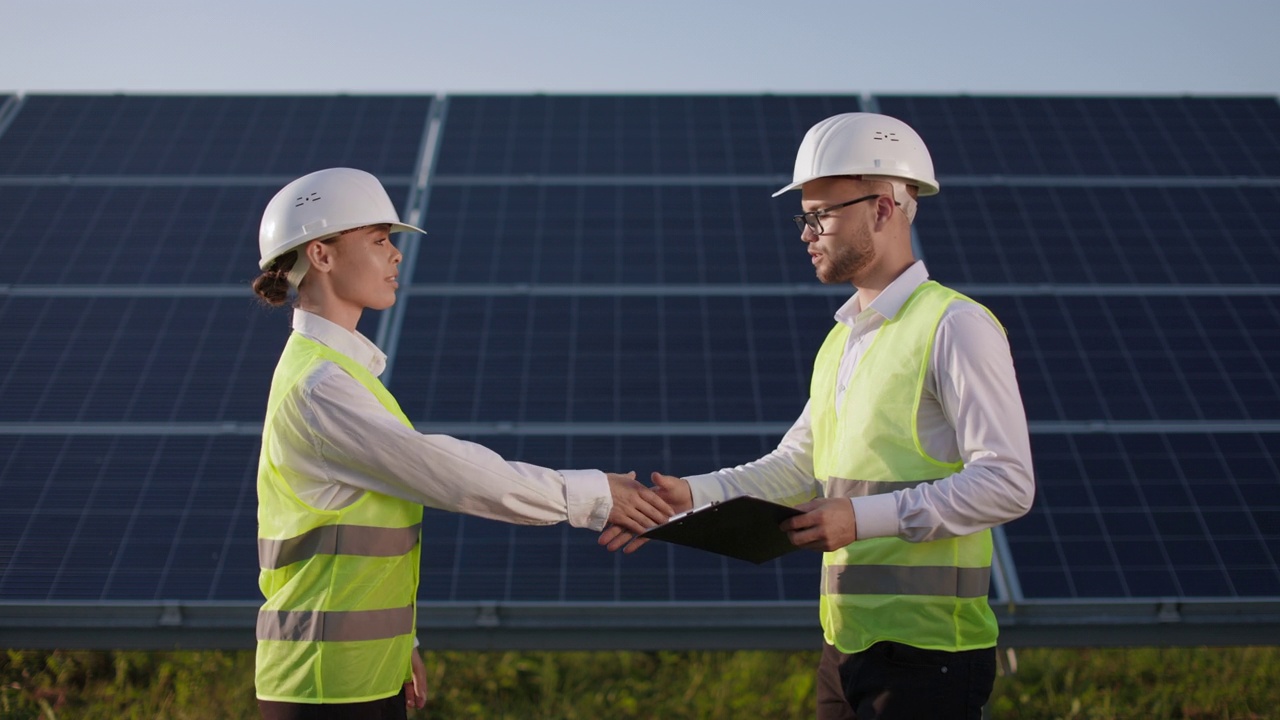 男子和女子在视察太阳能发电厂时握手。视频下载