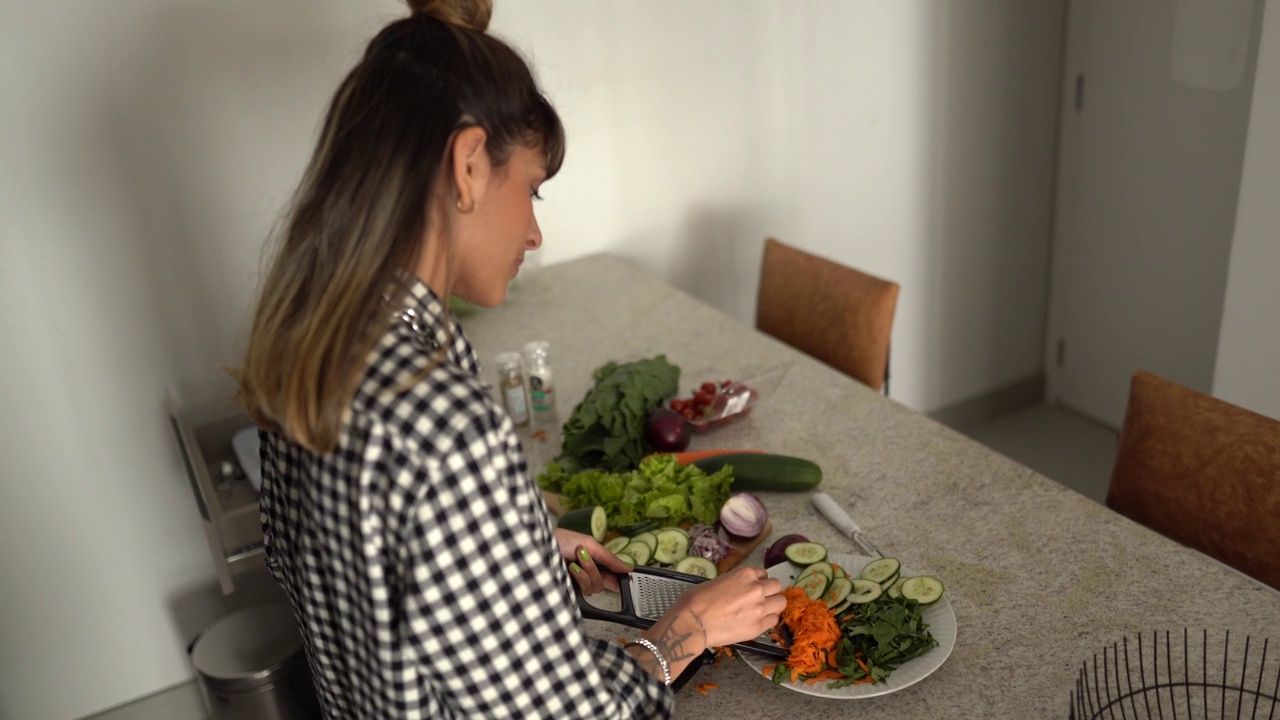 一名年轻女子在家里刨蔬菜的画像视频下载