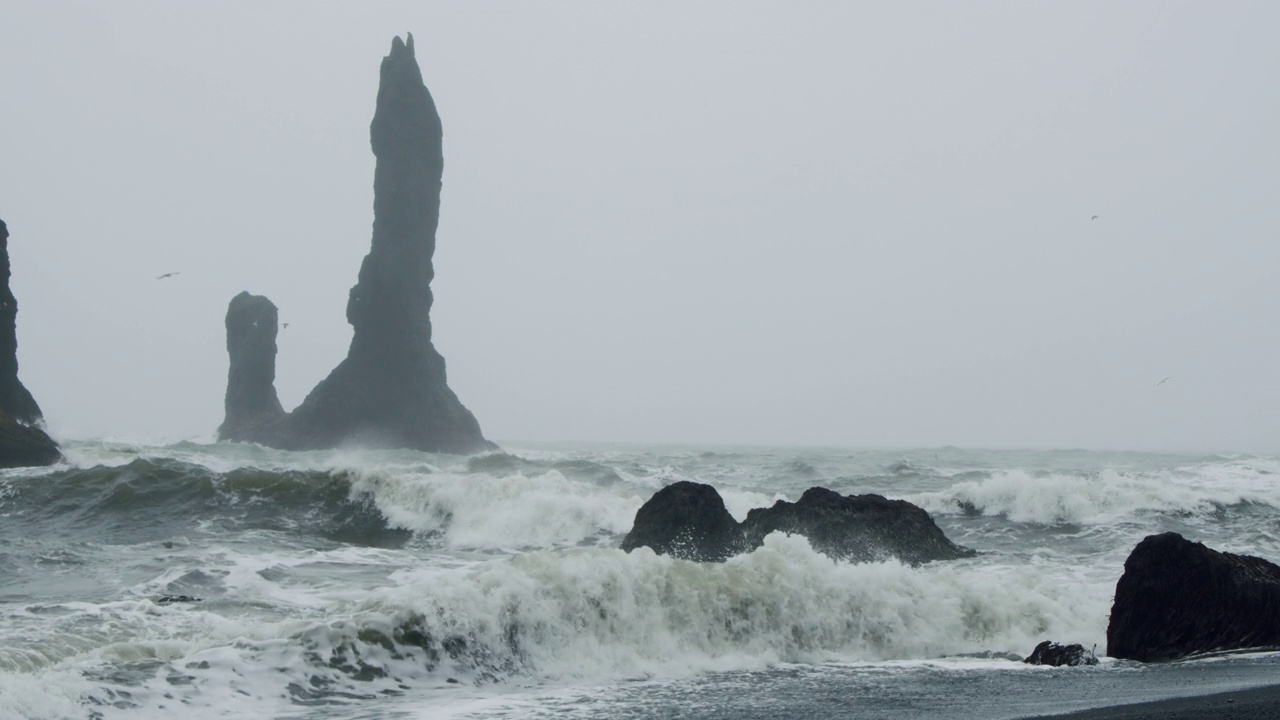 冰岛维克的Reynisfjara黑沙滩上的悬崖和海浪视频下载