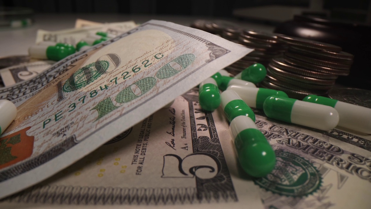 美元钞票和硬币躺在医用胶囊中视频素材