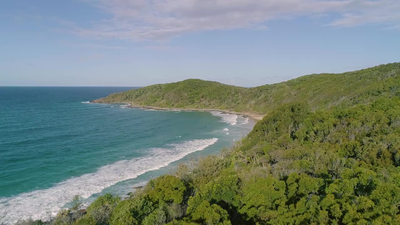 一个美丽的空中/无人机拍摄的原始热带海滩天堂，与水晶清澈的绿松石水遇见雨林。拍摄于仲夏时节，澳大利亚阳光海岸的努沙。拍摄在惊人的4K分辨率视频素材