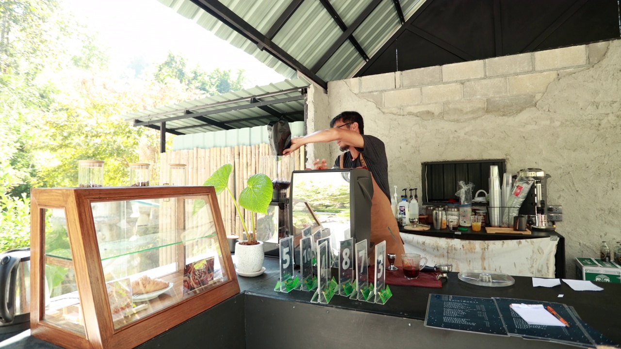 一位亚洲咖啡师在咖啡店里为顾客煮咖啡视频素材