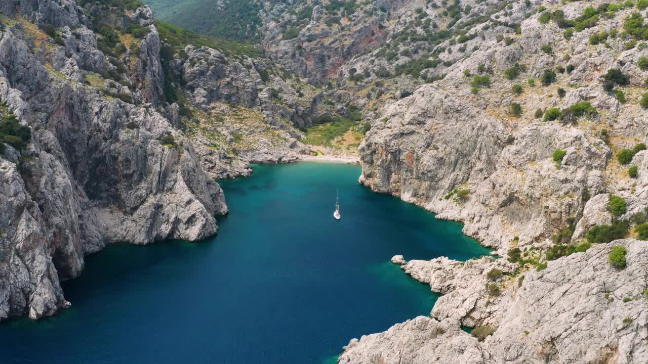 土耳其岩石海岸附近的游艇鸟瞰图。游艇，海上豪华度假视频下载