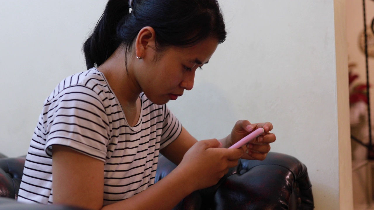 亚洲年轻女性使用手机视频下载
