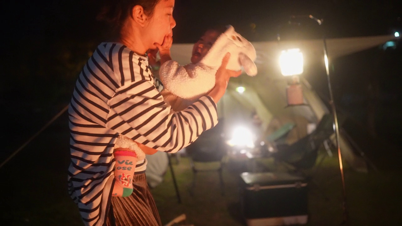 幸福和团聚亚洲母亲拥抱女儿休闲围绕篝火露营周末户外生活活动视频下载