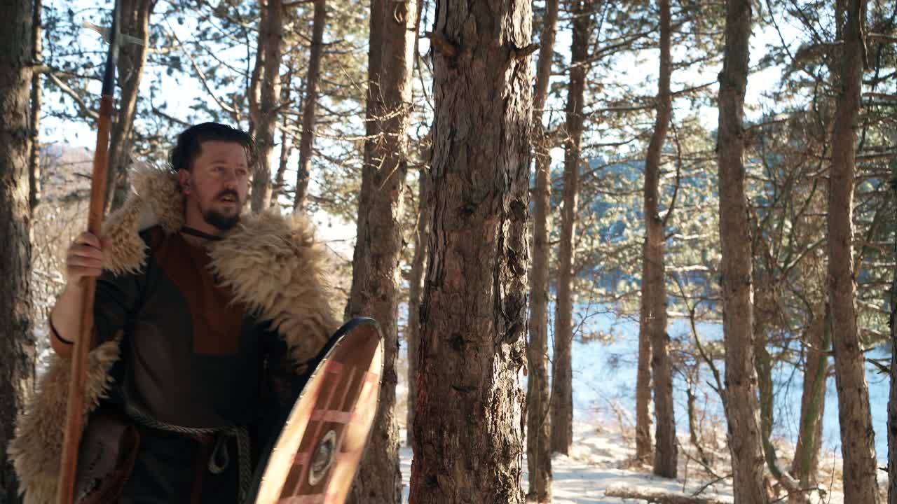 中世纪武士，冬天手持长矛和盾牌在森林中行走视频下载