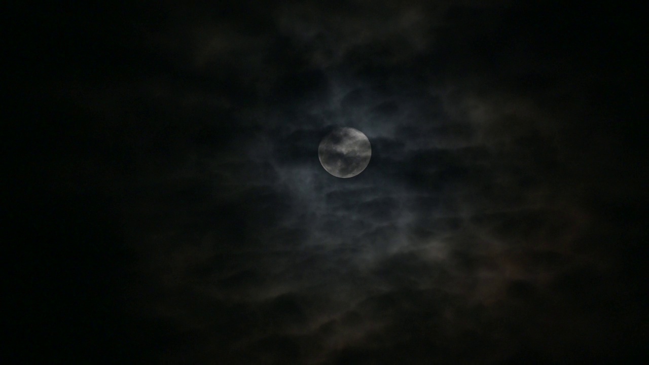 云在月圆时移动，大气看起来神秘而可怕。4 k的视频。视频素材