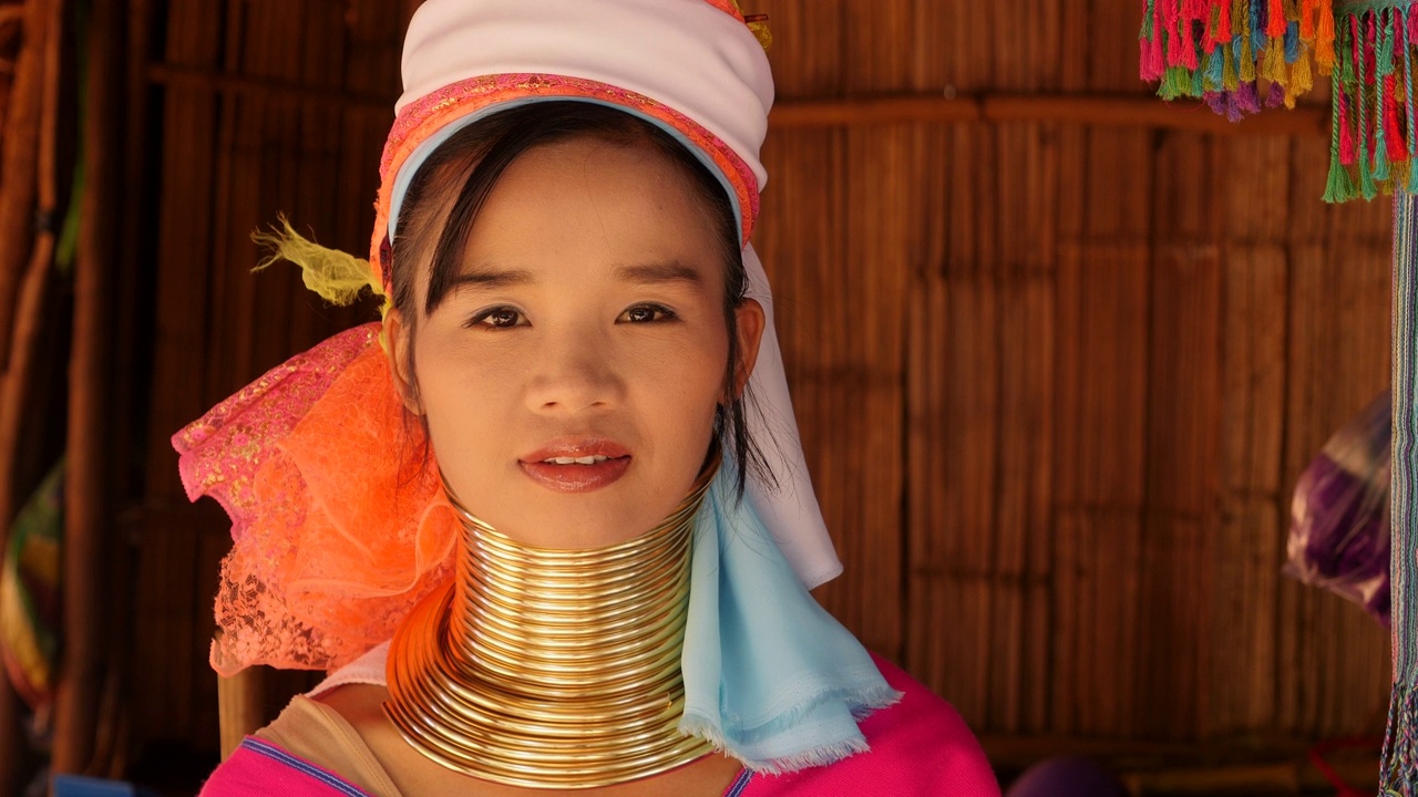 年轻的卡伦长脖子妇女穿着传统服装和脖子环在清莱附近的山区部落村庄，泰国北部视频素材
