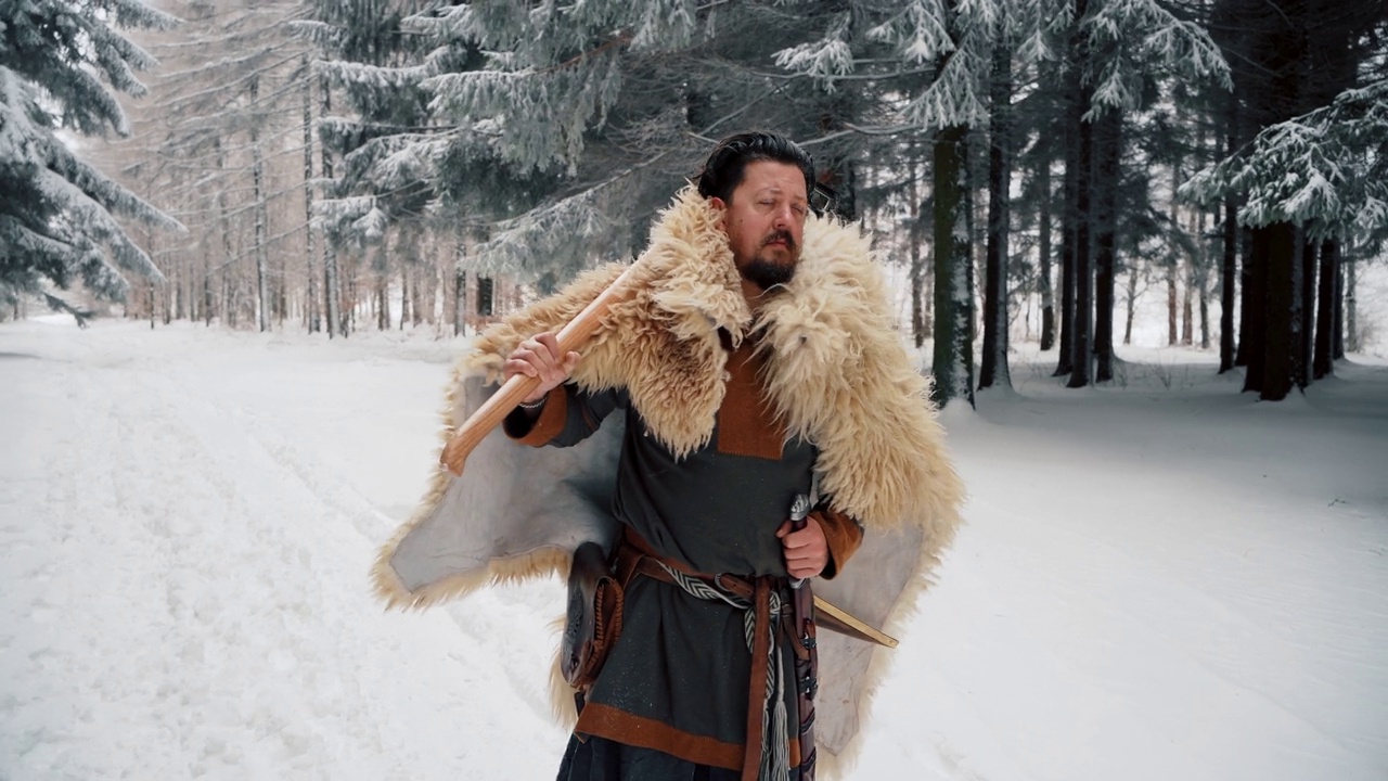 正面是一个自信的中世纪中年武士，手持斧头，站在森林里视频下载