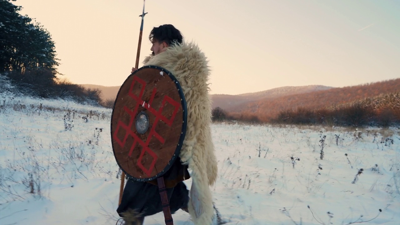 中世纪武士，手持长矛和盾牌在日落时分的森林中行走视频下载