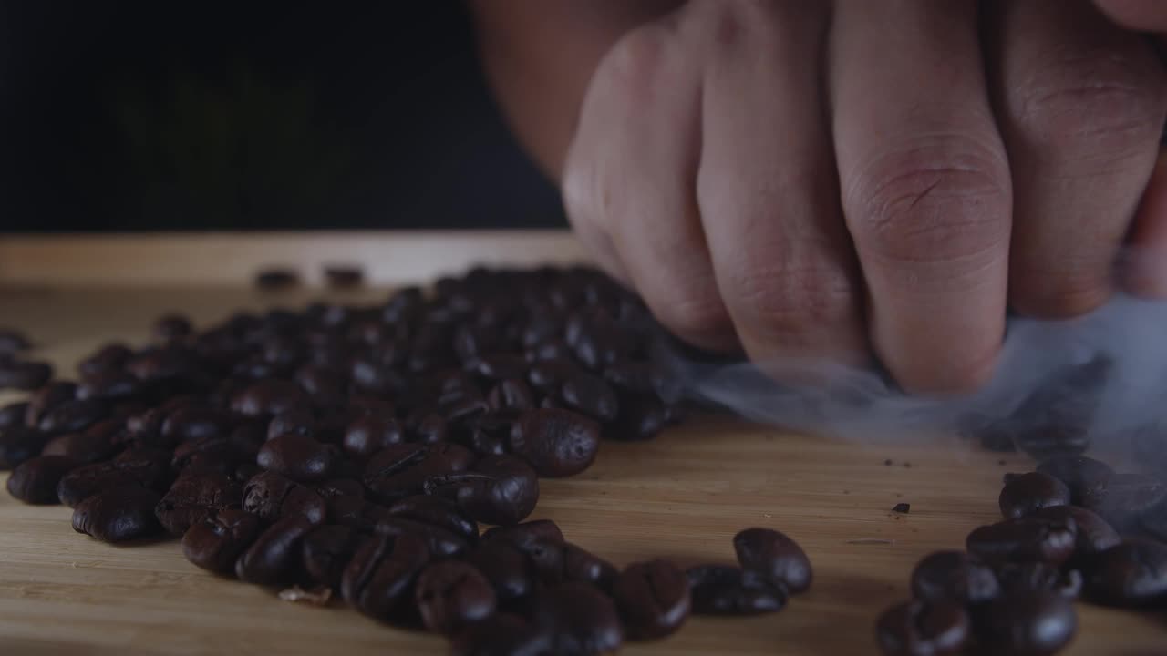 农夫的手拿起一把刚烤好的带烟的咖啡豆视频下载